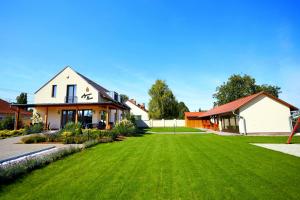 a house with a large yard with green grass at Agancsos Panzió Villány in Villány