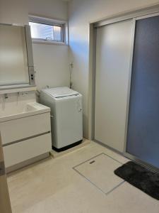 a laundry room with a washer and dryer and a sink at Aoshima Seaside Village in Miyazaki