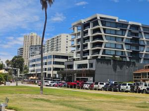 a parking lot with cars parked in front of a building at Avocet Apartment in Perth