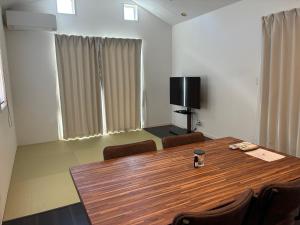 a conference room with a wooden table and chairs at Aoshima Seaside Village in Miyazaki