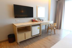 a room with a desk with a television on a wall at Hisea Huahin Hotel in Hua Hin