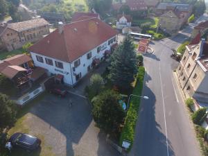 una grande casa bianca con un tetto rosso su una strada di Hotel Kovarna a Děčín
