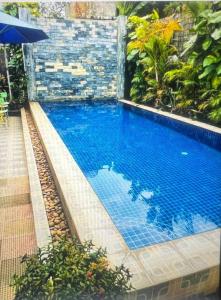 a swimming pool in a resort with a blue pool at Grand Apsara Residence in Siem Reap