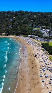 a group of people on a beach with the ocean at Lorne Holiday House in Lorne