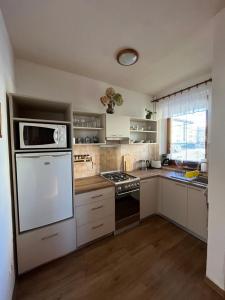 a kitchen with a stove and a microwave at Privát Kováč in Tatranská Lomnica
