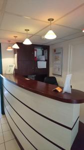 a reception desk in a hotel lobby with lights at Premiere Classe Besancon Ecole Valentin in Besançon