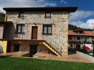 una casa de piedra con una escalera delante de ella en La Casuca, en Rasines