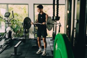 a man lifting a barbell in a gym at Golden Beach Resort in Koh Rong Island