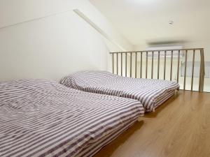 two beds sitting next to each other in a room at 宜蘭好窄平價民宿 in Zhuangwei