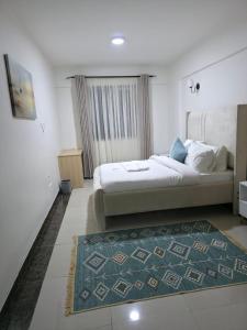 a bedroom with a large bed and a rug at LJ Homes in Nairobi