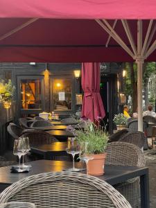 a restaurant with tables and chairs and a red umbrella at Schöne Aussicht - charmante Ferienwohnung mit Pool und Sauna in Bad Harzburg in Bad Harzburg
