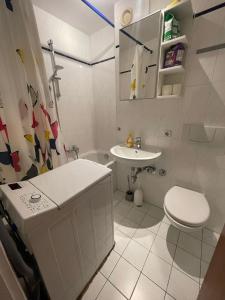 a white bathroom with a toilet and a sink at Cosy Accommodation - very central in Munich +27 photos