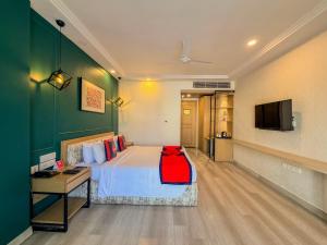 a hotel room with a bed and a television at Spree Hotel Kriday Rajpur Road Dehradun in Dehradun
