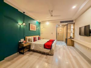 a bedroom with a bed and a green wall at Spree Hotel Kriday Rajpur Road Dehradun in Dehradun +39 photos