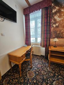 a room with a desk and a window at Folwark Historic Hotel in Warsaw +25 photos