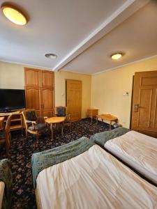 a hotel room with two beds and a desk at Folwark Historic Hotel in Warsaw