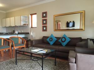 sala de estar con sofá, mesa y espejo en Keurbooms River Lodge 1311 en Plettenberg Bay