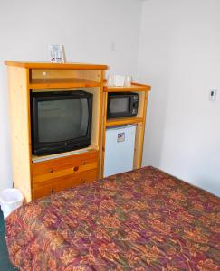 a room with a bed and a tv and a bed gmaxwell gmaxwell gmaxwell at Central Motel in Great Falls