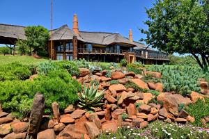 a house with a garden of rocks in front of it at African Hills Safari Lodge & Spa in Magaliesburg