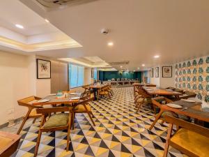 a dining room with wooden tables and chairs at Spree Hotel Kriday Rajpur Road Dehradun in Dehradun