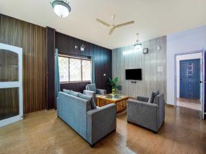 ein Wohnzimmer mit Sofas und einem Fernseher in der Unterkunft Palette Mountain Mist Villa | 2BHK | Jacuzzi | Pool | Lonavala in Lonavla