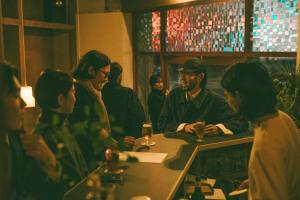 a group of people sitting at a table in a bar at ONYO Hotel and Lounge in Ueda