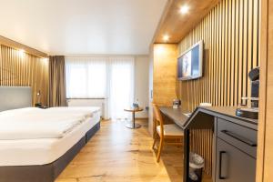 a hotel room with a bed and a desk at Seemöwe Wellnesshotel Swiss Quality in Güttingen