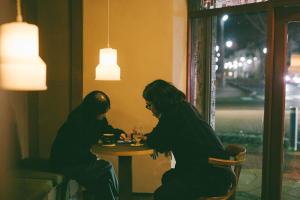 two people sitting at a table in a restaurant at ONYO Hotel and Lounge in Ueda