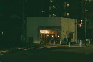a building with a lit up door at night at ONYO Hotel and Lounge in Ueda