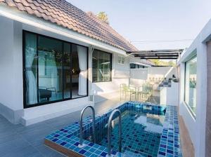 a house with a swimming pool next to a house at Villanin Hotel & Spa Golden Triangle in Ban Wiang Nuea