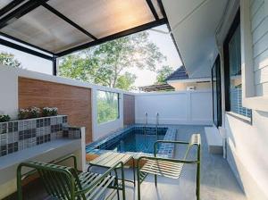 a swimming pool in a house with a table and chairs at Villanin Hotel & Spa Golden Triangle in Ban Wiang Nuea