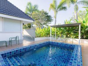 a swimming pool in front of a house at Villanin Hotel & Spa Golden Triangle in Ban Wiang Nuea