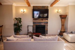 a living room with a couch and a fireplace at The Gables-Clarens in Clarens