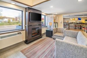 a living room with a fireplace and a tv at Comfort Inn Moncton East in Moncton