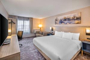 a hotel room with a large bed and a living room at Comfort Inn Moncton East in Moncton