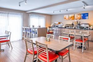 a restaurant with tables and chairs and a bar at Comfort Inn Moncton East in Moncton