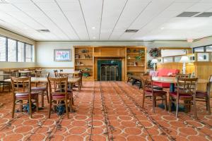 a dining room with tables and chairs and a fireplace at Quality Inn & Suites Monroe in Monroe
