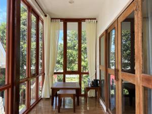 a room with large windows and a wooden table at Alicia Resort in Koh Rong Island