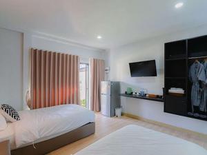 a white room with a bed and a refrigerator at Villanin Hotel & Spa Golden Triangle in Ban Wiang Nuea