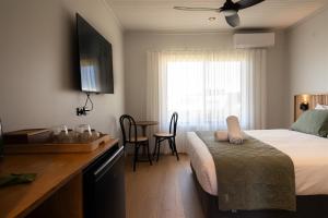 a bedroom with a bed and a desk with a table at Augusta Hotel Motel in Augusta