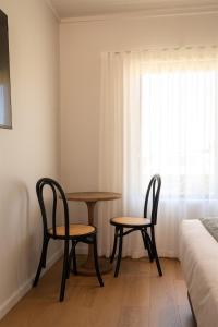 a room with two chairs and a table and a bed at Augusta Hotel Motel in Augusta +18 photos