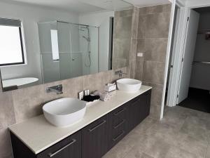 a bathroom with two sinks and a large mirror at The Ponds at Mudgeeraba in Gold Coast +20 photos