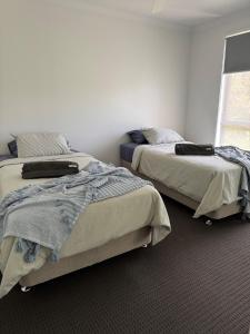 a bedroom with two beds and a window at The Ponds at Mudgeeraba in Gold Coast