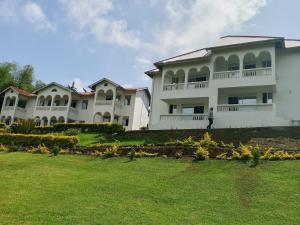 a man standing in front of a large white house at Taita Rocks Hotel in Wundanyi +11 photos