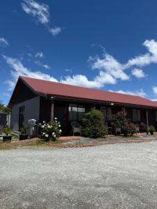 a building with a red roof on a street at #4 Glenorchy Alpine Suite in Glenorchy
