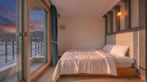 a bedroom with a bed and a large window at Gyeongju Gamposole Pension in Gyeongju +2 photos