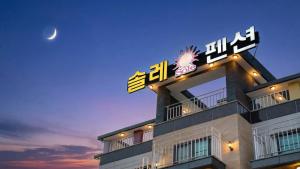 a building with a sign on top of it at night at Gyeongju Gamposole Pension in Gyeongju