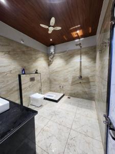 a bathroom with a shower and a toilet and a sink at Hotel Shree Sanwaliya in Ujjain