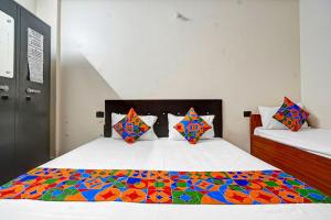 a bedroom with a bed with a colorful comforter at Via Lords inn in Bhopal +19 photos