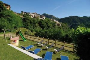 a group of lawn chairs and a playground on a hill at Agriturismo La Zangola in Tremosine Sul Garda